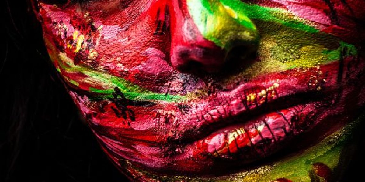 15587977 - close-up portrait of an artistic woman painted with red   green color  part of face photo